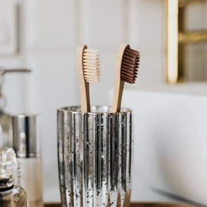 Bamboo toothbrushes in glass in stylish bathroom