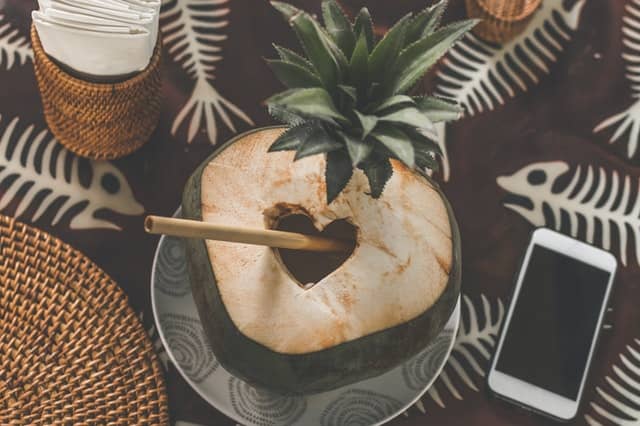 Coconut Juice With Bamboo Straw Near Smartphone